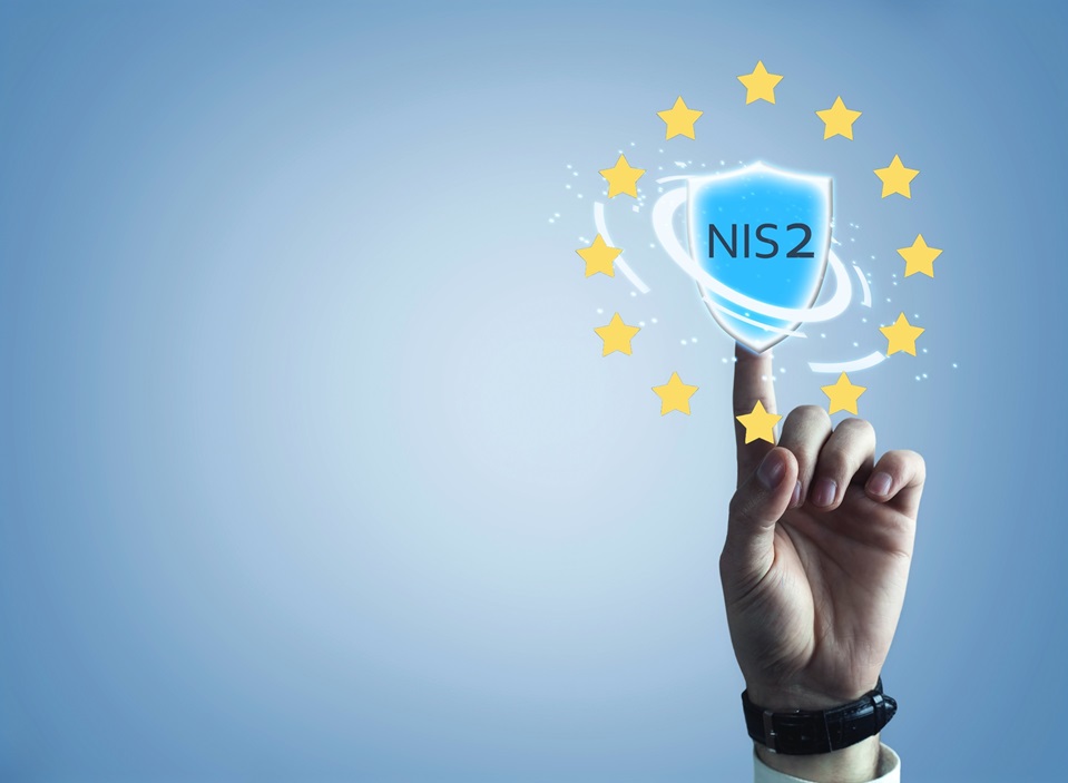 Hand berührt ein Schutzschild mit der Aufschrift NIS2 im EU-Sternenkreis